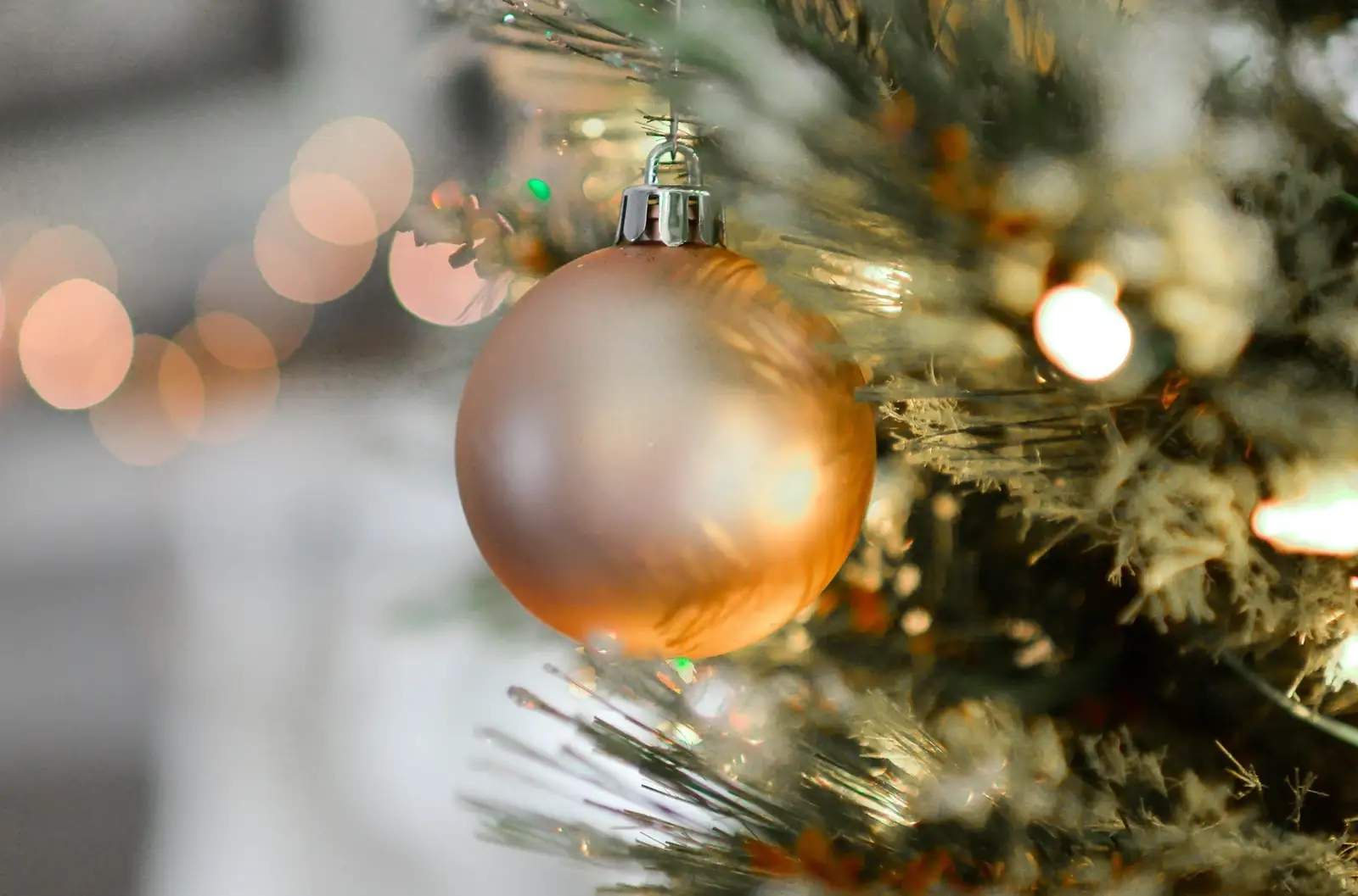 A gold bauble on a Christmas tree at an office Christmas party that is being catered from by Sadlergates.
