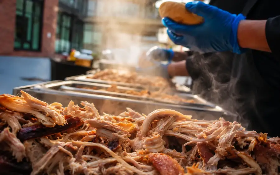Hog roast machine set up under a gazebo at an outdoor event