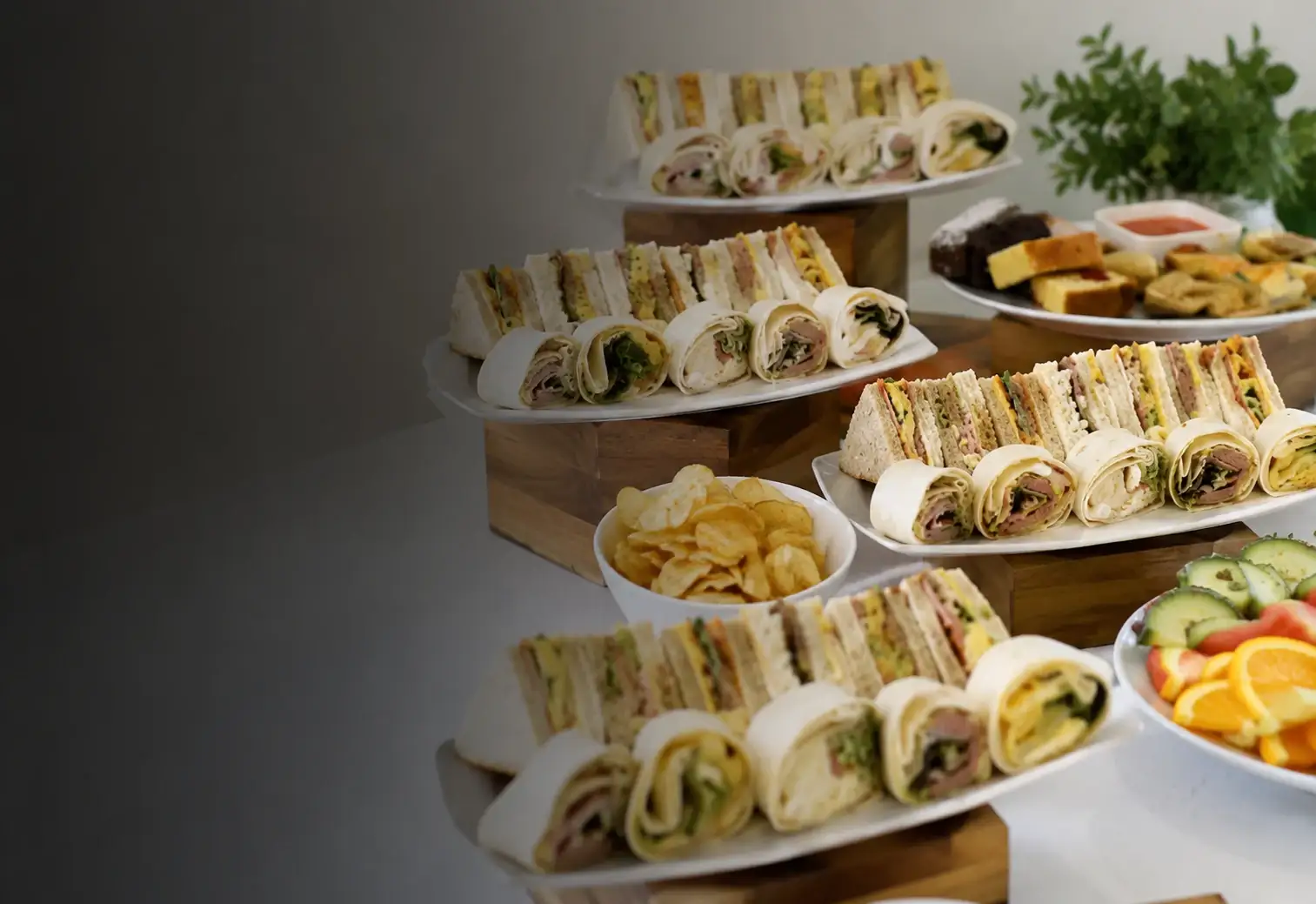 Platters of freshly made sandwiches, wraps and finger food laid out for a buffet
