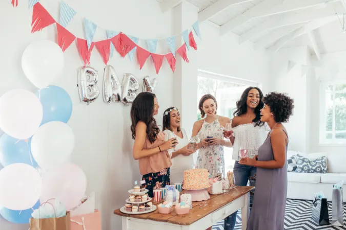 A mum-to-be and her friends at her baby shower eating cakes from the buffet which was organised to meet all guests needs.